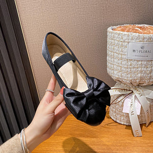 Black oversized bow Mary Jane ballet flat held in hand