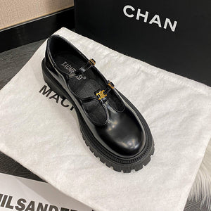 Black T-strap platform Mary Jane loafers displayed in a box