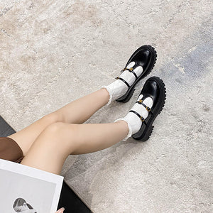 Black and white T-strap platform loafers worn