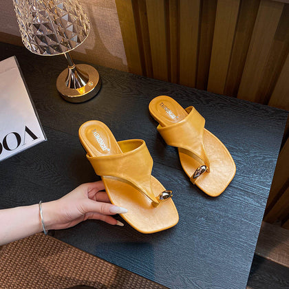 Yellow gold buckle toe-post sandals held in hand