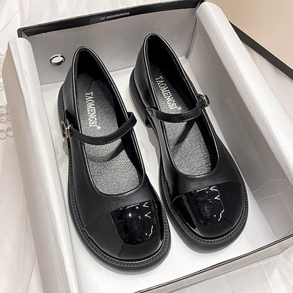 Black cap-toe platform Mary Jane pumps in a box