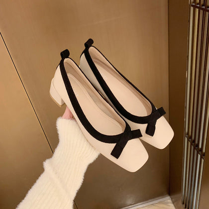 Apricot square-toe bow block heel pumps held in hand