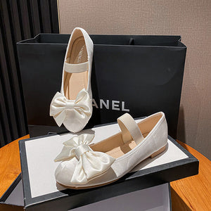 White oversized bow Mary Jane flats displayed in a box