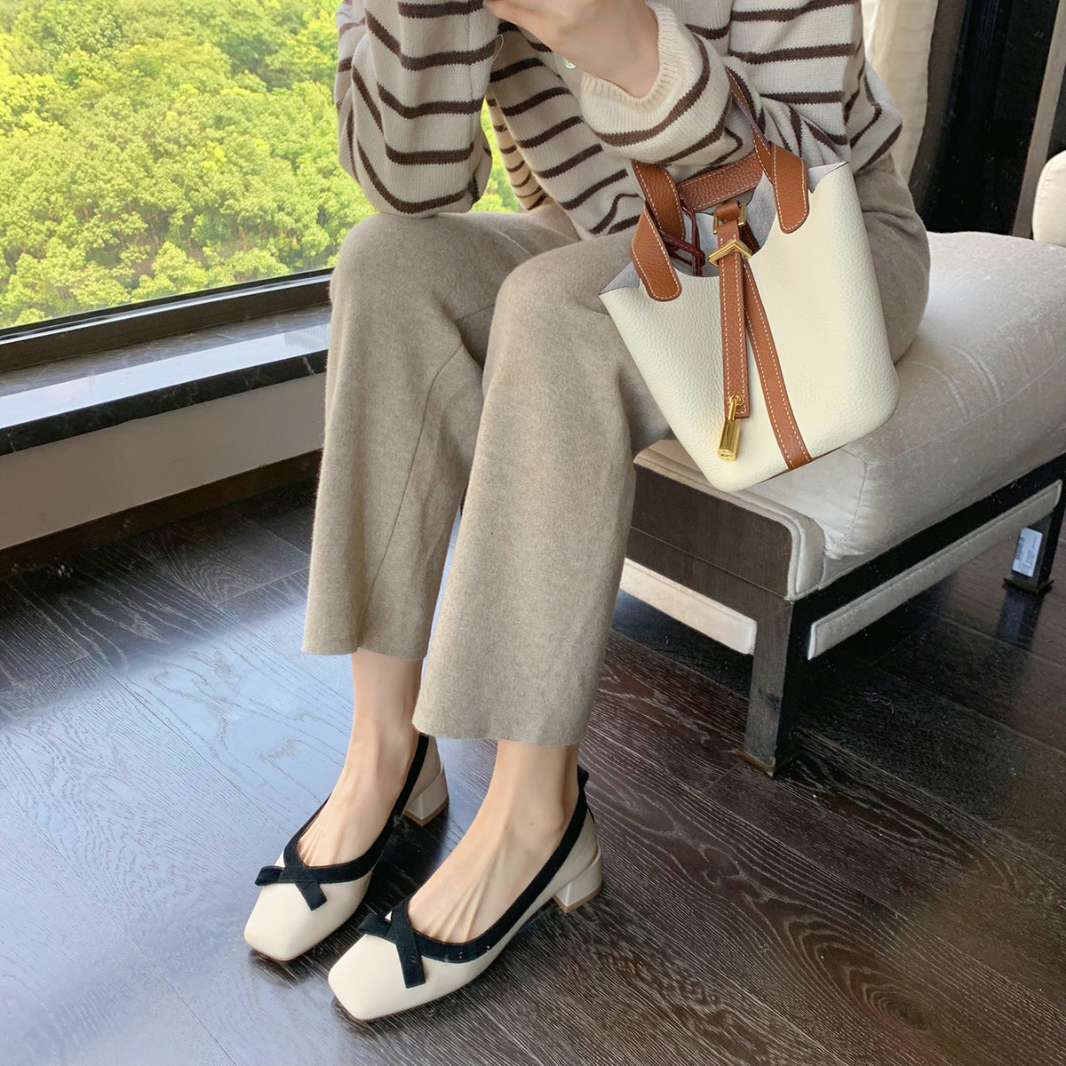 Apricot bow block heel pumps worn by a window