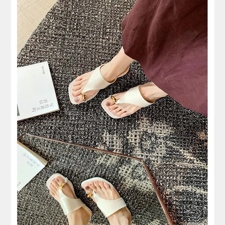 White square-toe toe-post sandals worn on a patterned rug