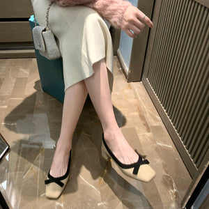 Apricot bow square-toe pumps worn while seated